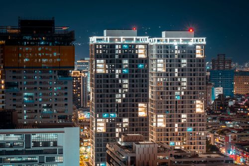 Free Aerial view of illuminated high-rise buildings in a bustling urban night scene. Stock Photo