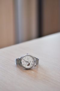 Steel bracelet watch on a wooden table — photo by Ninety Seven Years on Pexels