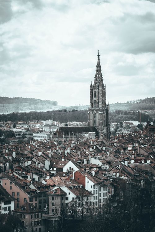 Free Aerial view of Bern's iconic cathedral with traditional rooftops under an overcast sky in Switzerland. Stock Photo
