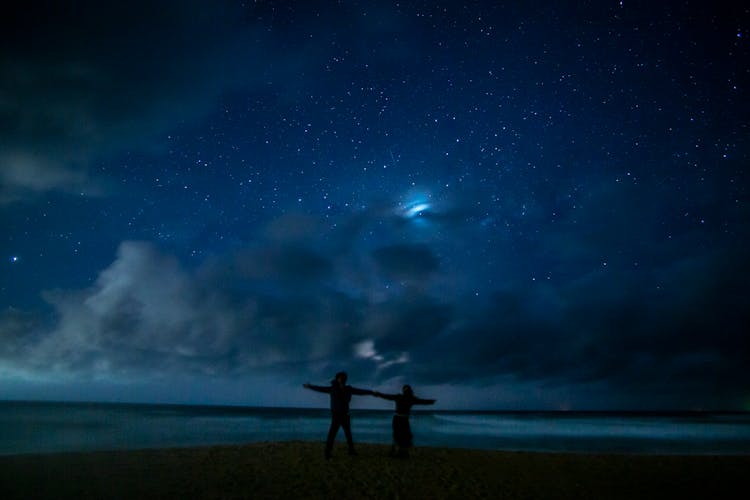 A Couple On The Beach At Nighttime