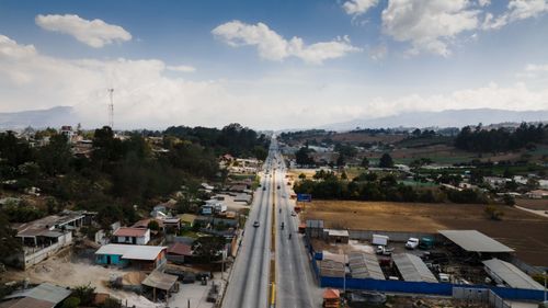 Free Drone shot of a highway cutting through rural countryside with small communities on either side. Stock Photo