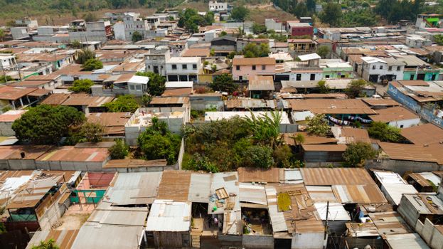 Aerial photo showcasing an urban slum with rusted rooftops and dense housing.