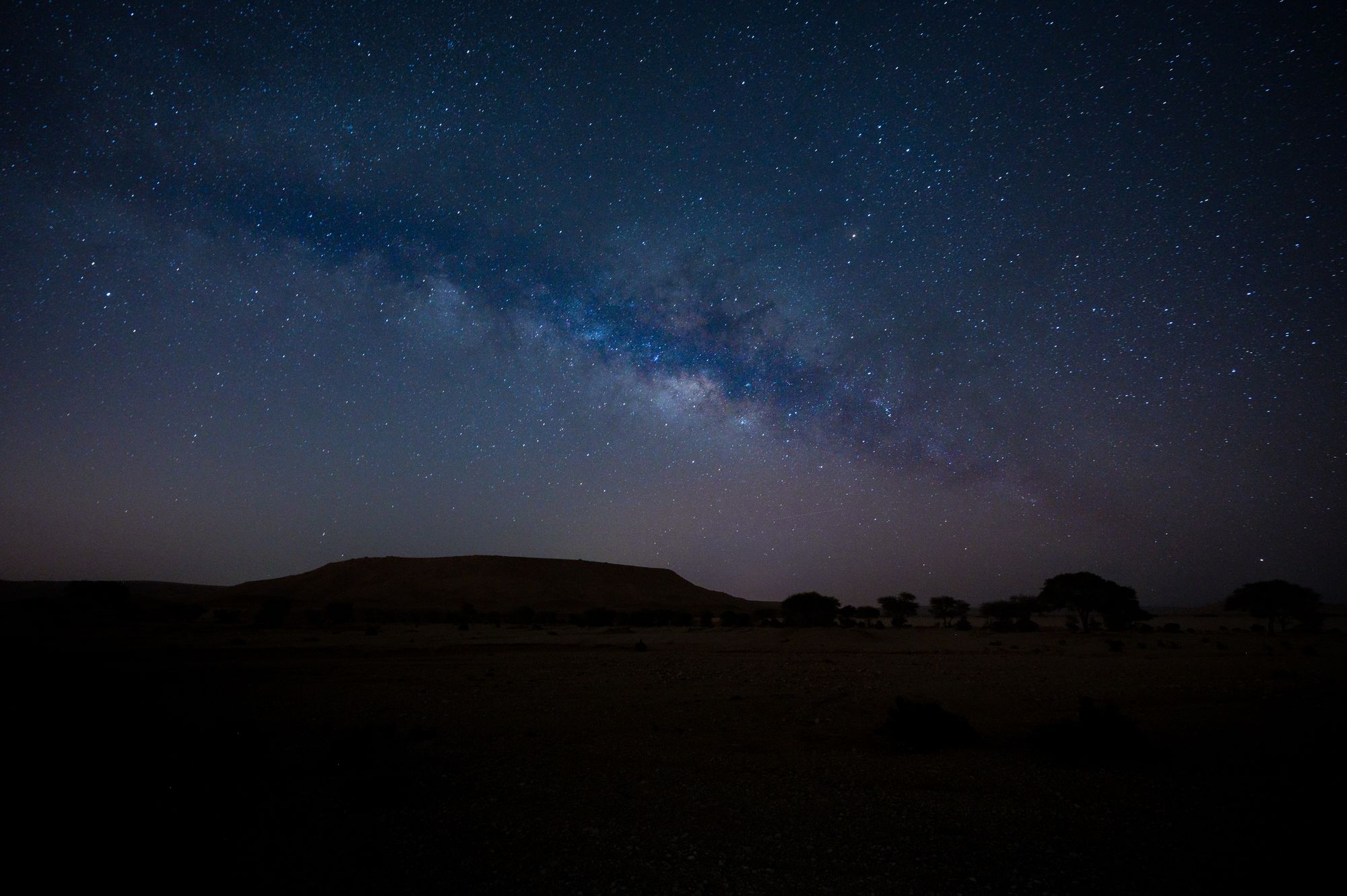 A stunning view of the Milky Way galaxy above a serene desert landscape.