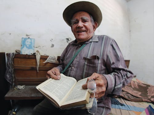 Free An Elderly Man Holding a Book Stock Photo