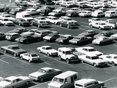 Aerial view of a parking lot filled with vintage cars in a classic black and white setting.