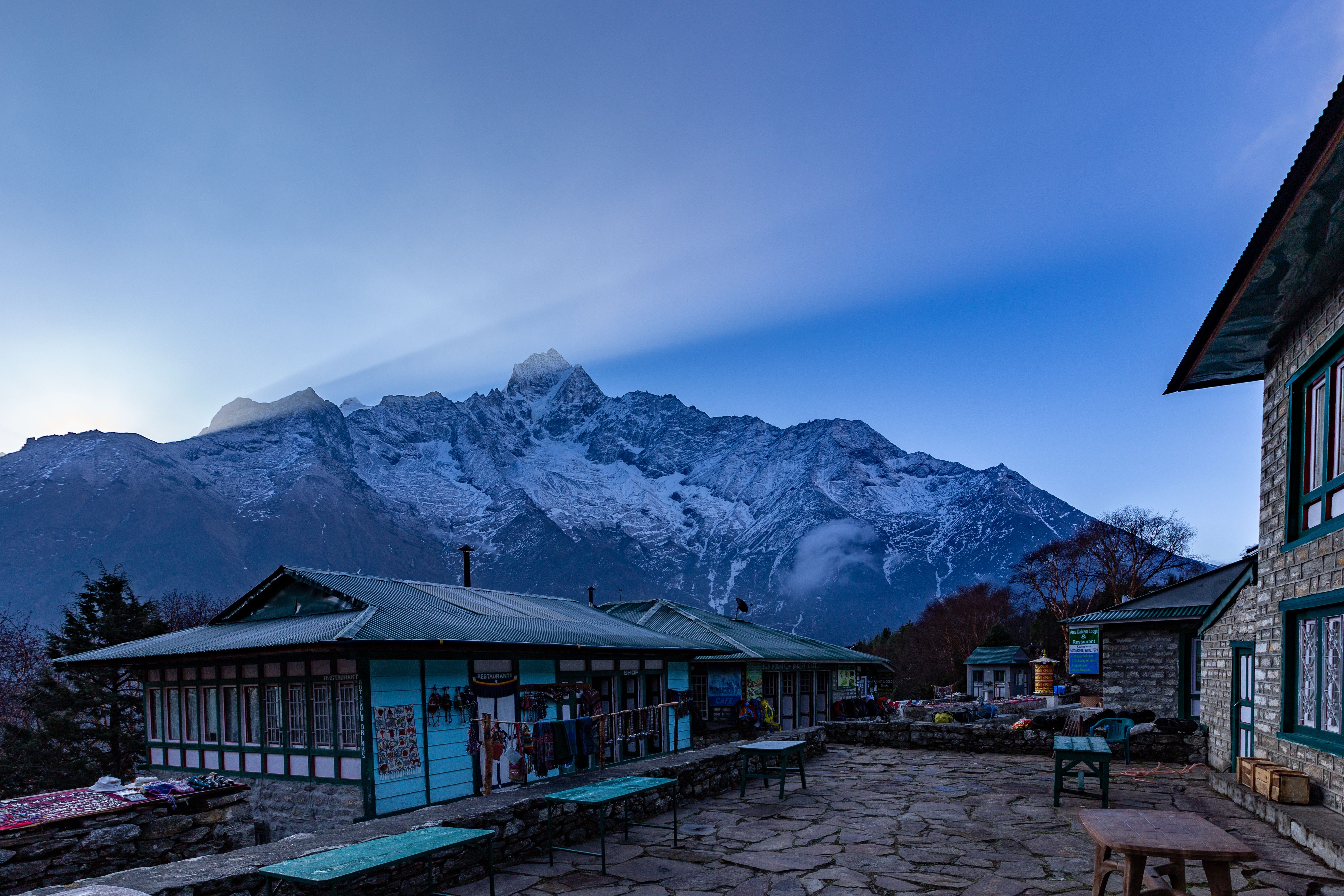 A teahouse courtyard at dawn beneath snow peaks