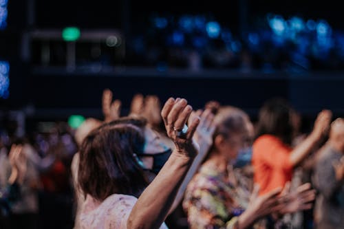 Selective Focus of a Woman Raising Her Hands