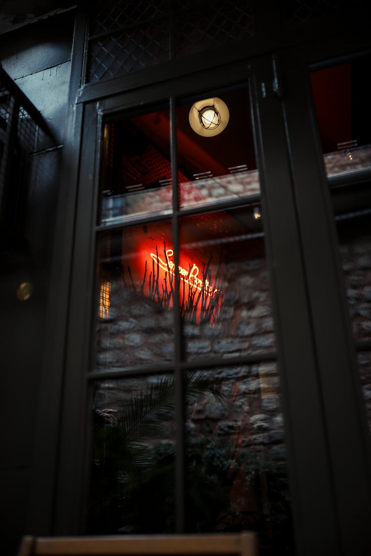 Neon Sign Reflecting In A Window