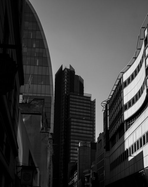 Free A striking monochrome view of modern buildings in an urban setting, capturing towering skyscrapers. Stock Photo
