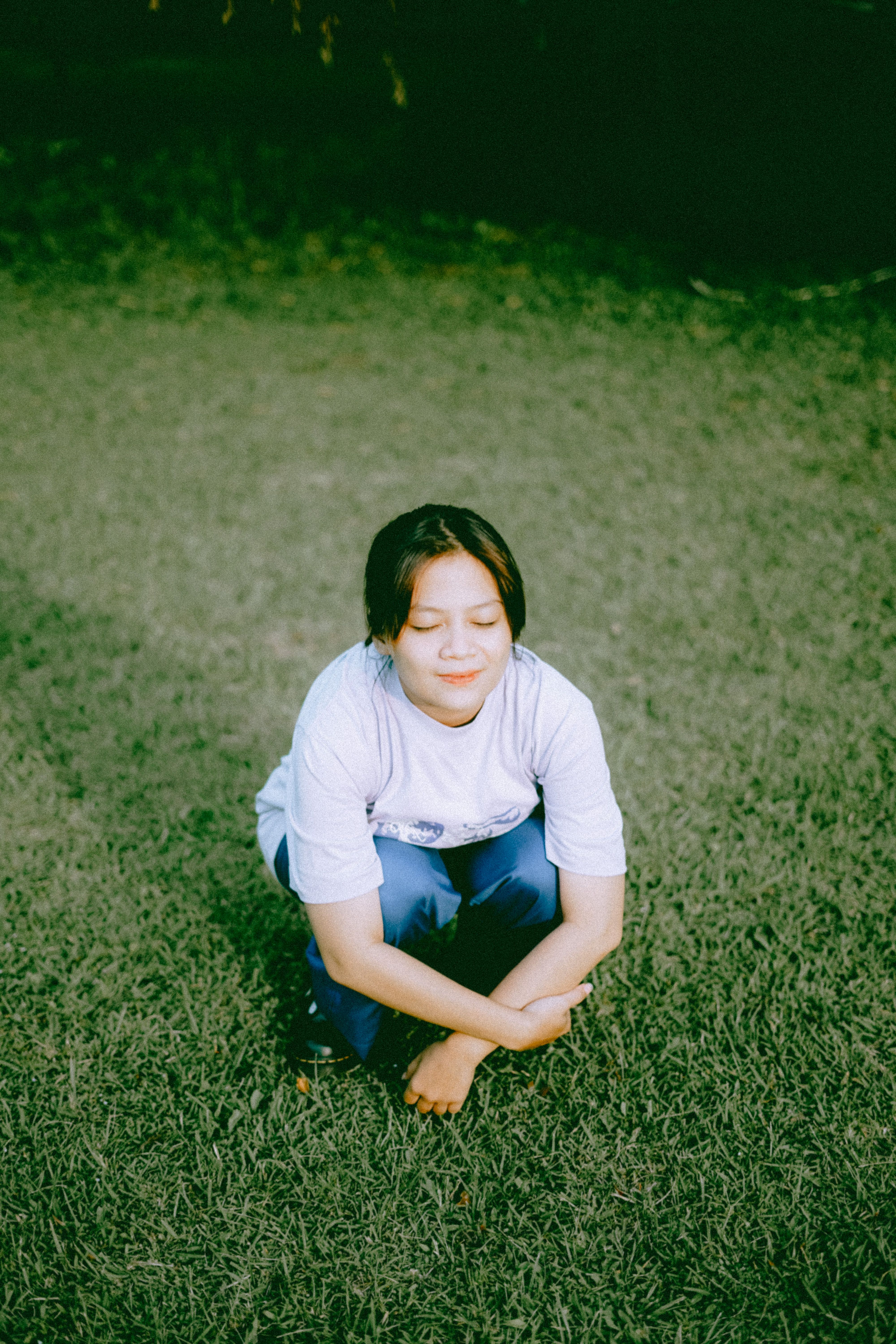 A Woman Sitting on a Grass While Eyes Closed · Free Stock Photo