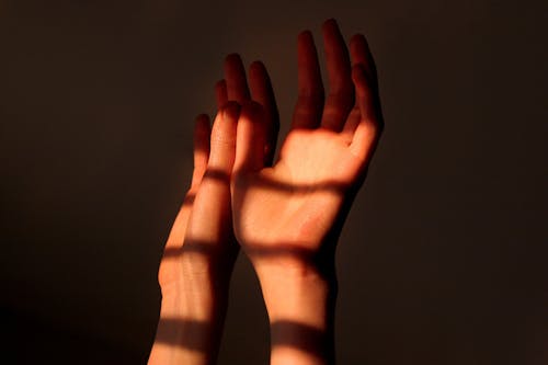 Close Up Photo of Shadow on Person's Hands