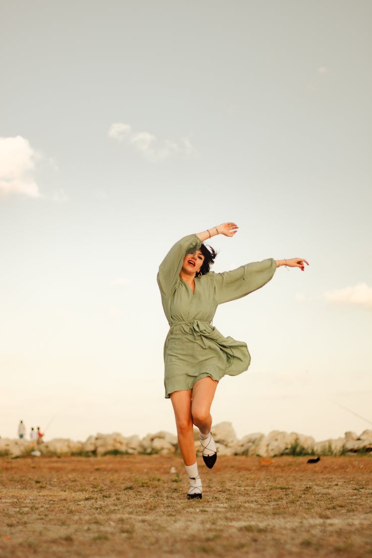 Woman In Dress Dancing In Field