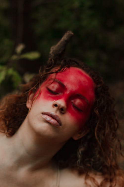 A Woman with Red Art Makeup Covering Her face