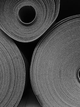 Monochrome photo of stacked rolled yoga mats, perfect for fitness-focused concepts.