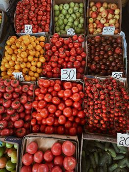 Vibrant arrangement of tomatoes and fruits at a market stall showcasing fresh produce.