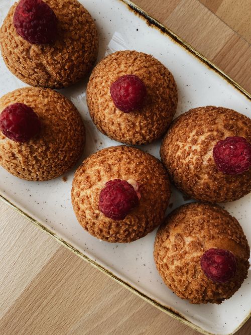 Free A mouthwatering arrangement of homemade pastries topped with fresh raspberries on a white platter. Stock Photo