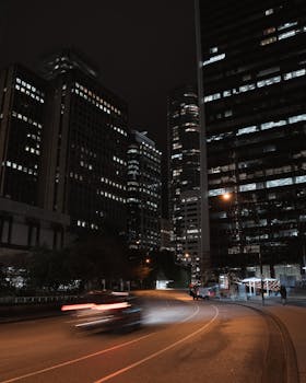 A dynamic urban night scene showcasing Vancouver's skyscrapers and bustling traffic.