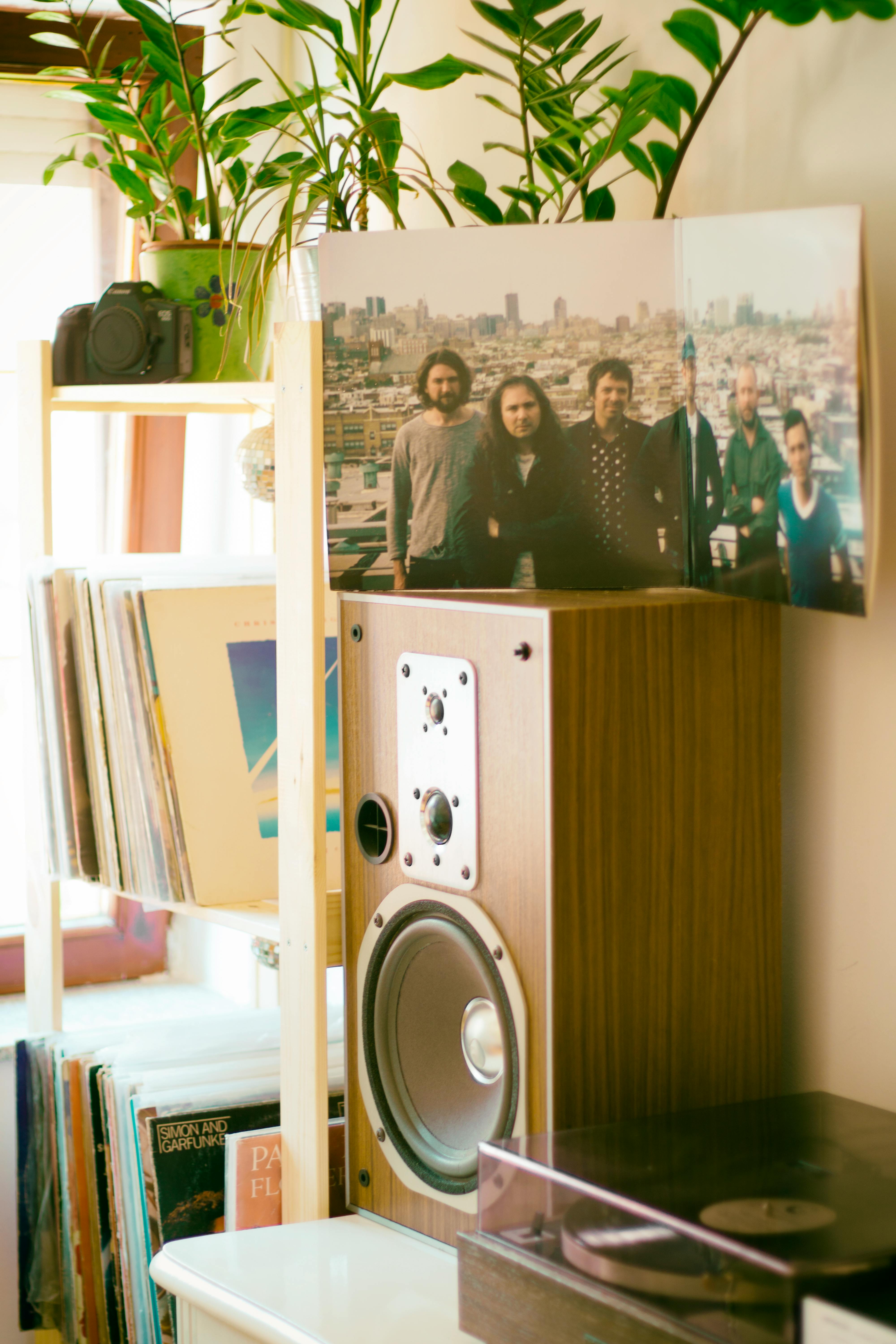 photo of group of men on top of brown speaker