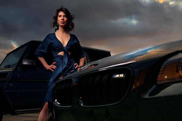 A Woman Standing Beside A BMW M5