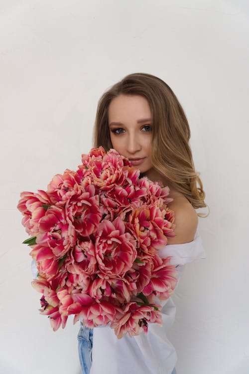 Close-Up Shot of a Blonde Woman Holding a Bouquet of Flowers