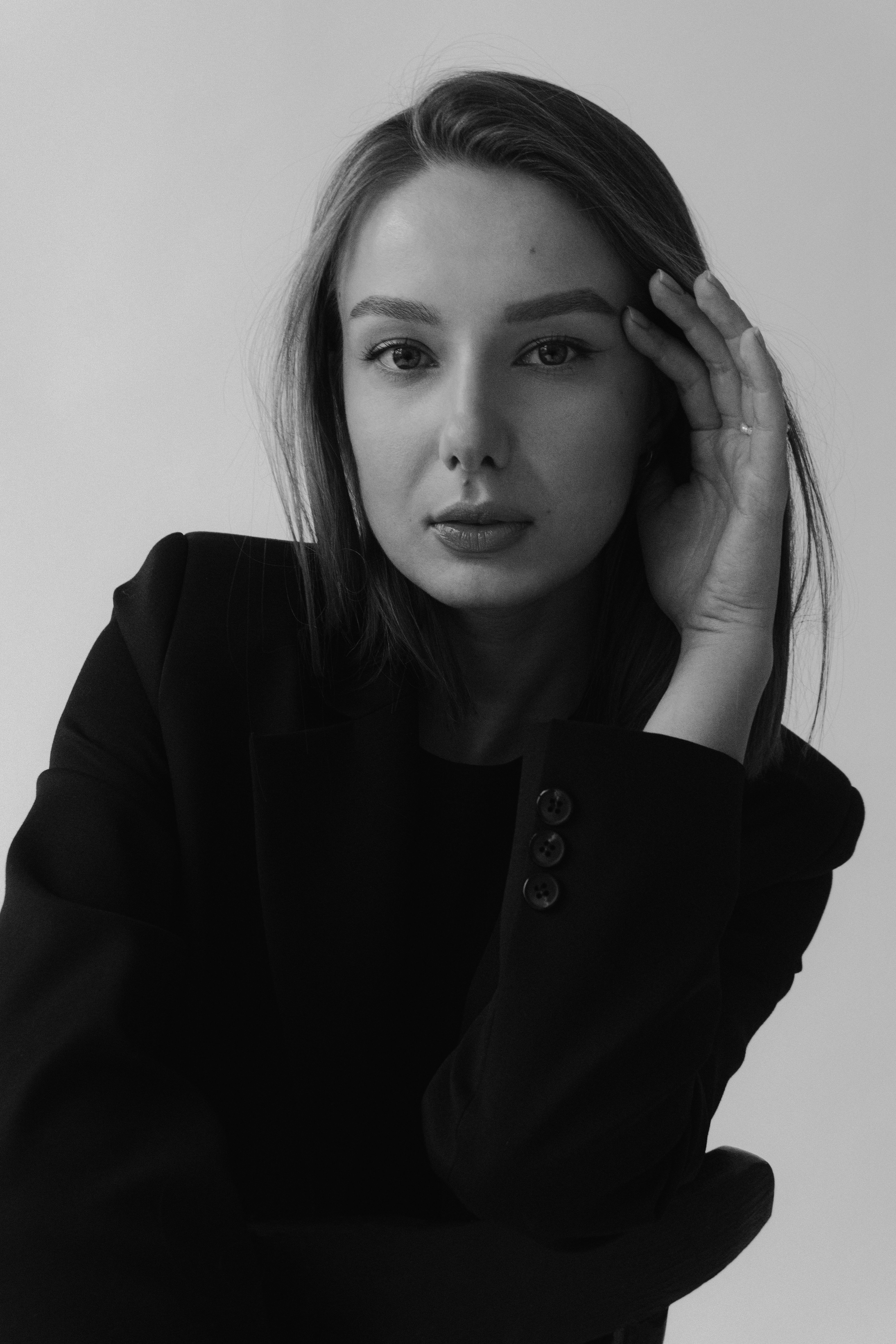 Elegant black and white portrait of a woman in a studio setting.