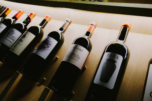 Free Wine Bottles on Brown Wooden Shelf Stock Photo