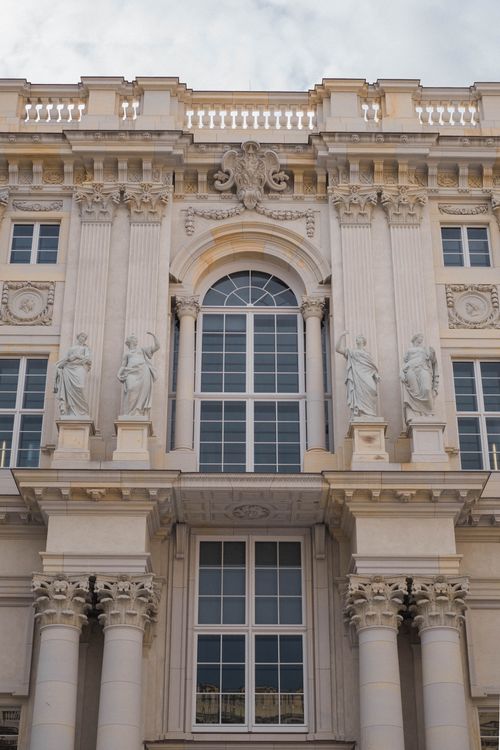 Free Magnificent classical building facade featuring ornate sculptures and columns under a clear sky. Stock Photo