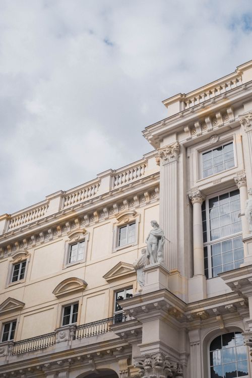 Free Elegant baroque building facade with ornate sculptures under a cloudy sky. Stock Photo