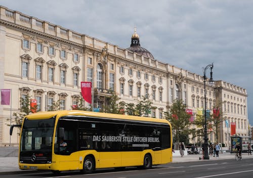 Free Yellow Bus Passing By Humboldt Forum in Berlin Stock Photo