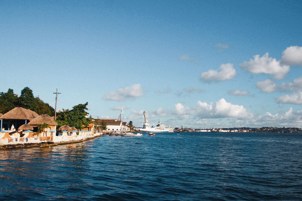 a picturesque harbor scene with boats blue sky and coastal buildings
