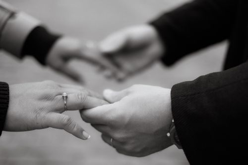 Free Close-up of a couple holding hands in a monochrome setting, symbolizing love and connection. Stock Photo