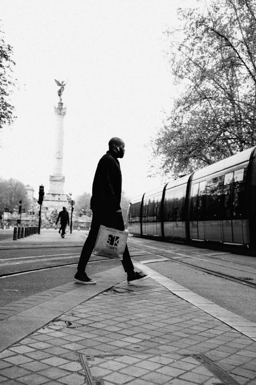 Free Man in Black Jacket Walking Near the Train Line Stock Photo