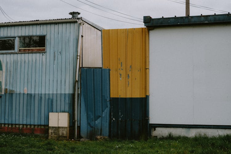 Corrugated Iron Fence Between Two Small Houses