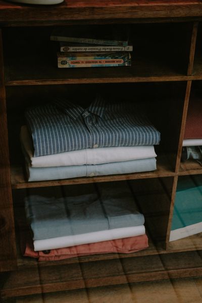 Shelf of neatly folded clothes — photo by Mathias Reding on Pexels