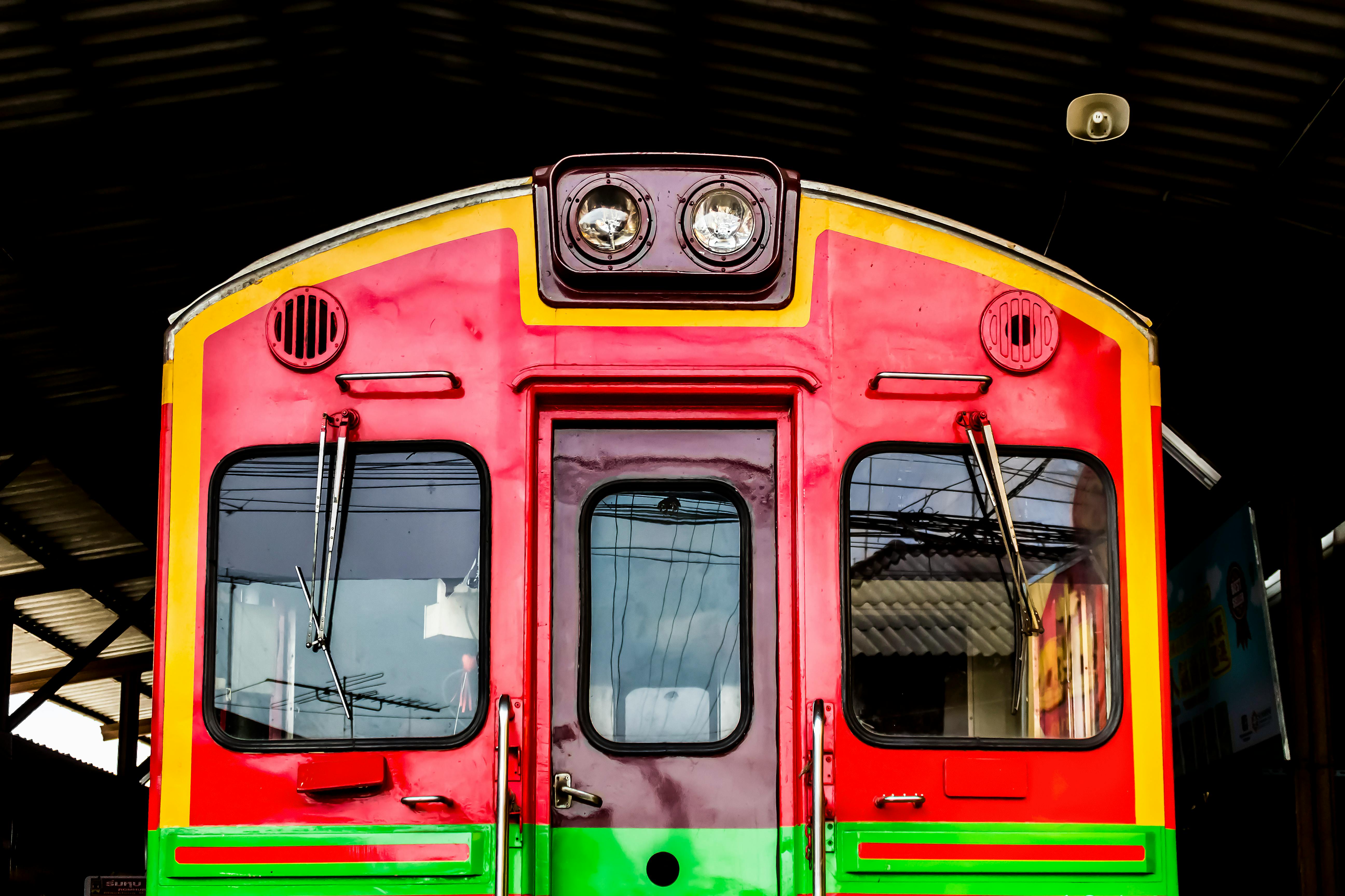 Free Vibrant red and green locomotive front view at a station in Bangkok, Thailand. Stock Photo
