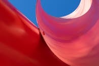 背景是亮蓝色天空，一座位于纽黑文的红色弧形雕塑呈现出抽象视图