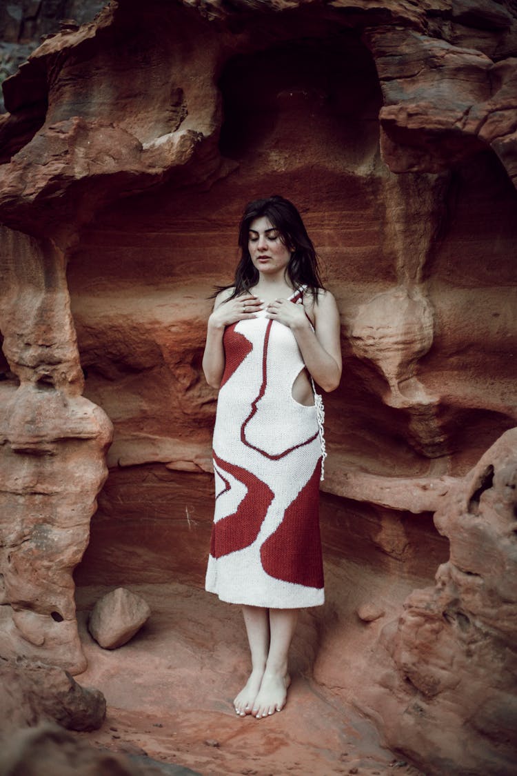 Female Fashion Model Posing In Front Of An Eroded Rock Wall