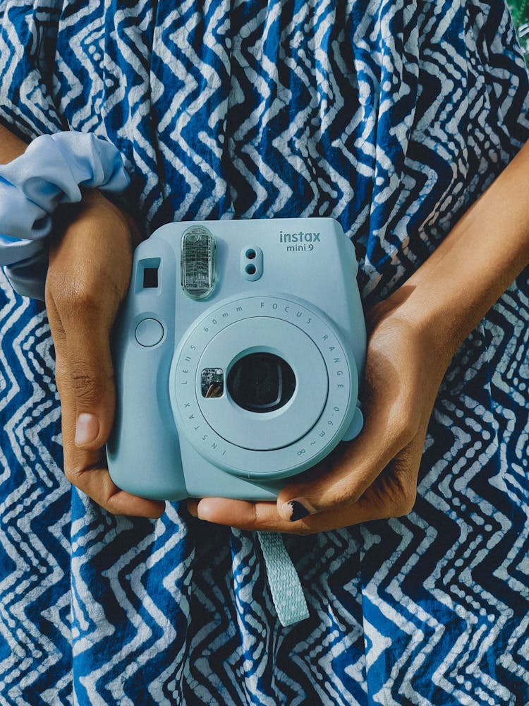 A Person Holding A Polaroid Camera