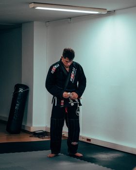 Martial artist tying belt in a quiet studio