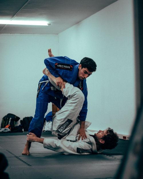 Free Two men practice Brazilian Jiu-Jitsu, demonstrating intricate grappling techniques indoors. Stock Photo