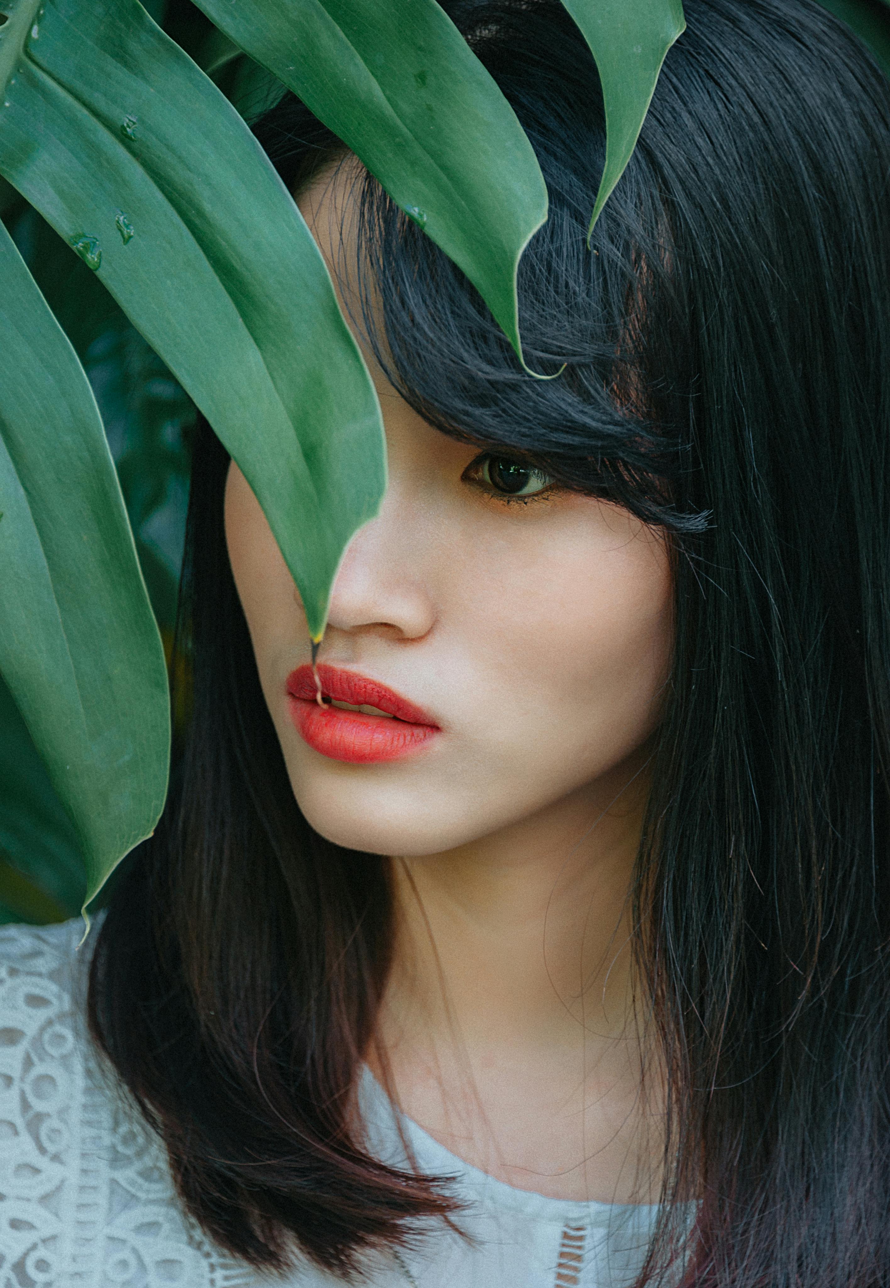 一幅部分被树叶遮挡的女性美丽肖像，捕捉到了优雅与神秘