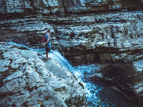 Man Standing in Waterfalls