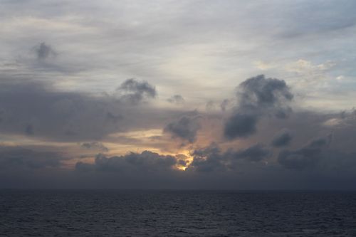 Free Serene ocean view at sunset with dramatic clouds and calming waves. Stock Photo