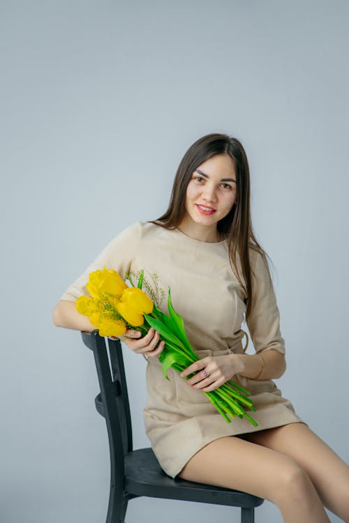 Portrait Of a Beautiful Woman Holding a Bouquet Of Yellow Tulips