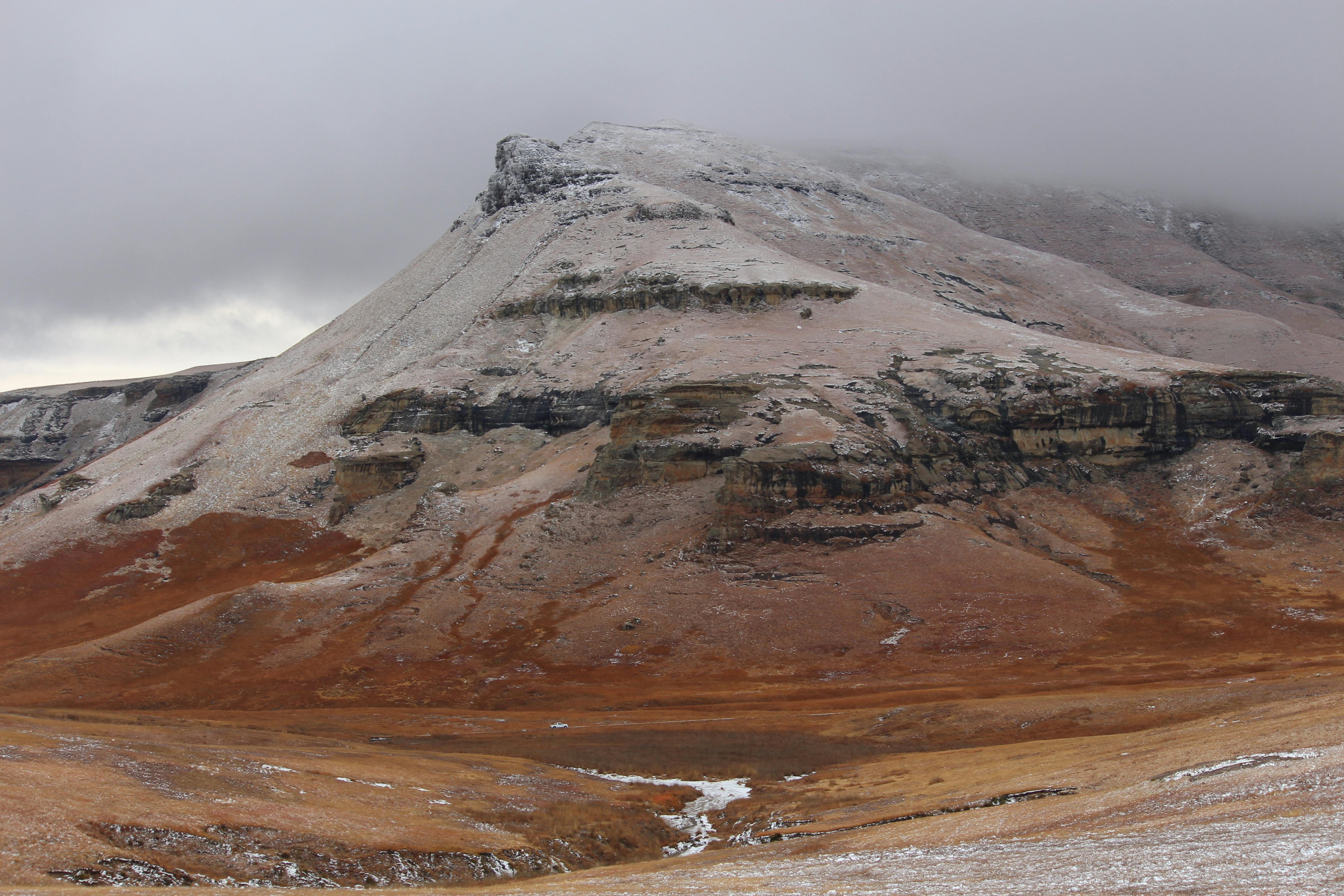 Prescription Goggle Inserts - A scenic view of a snow-dusted mountain with cloudy skies, capturing the beauty of nature.