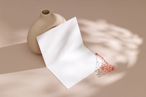 Free Elegant beige vase with blank card and dried flowers on a pink background. Stock Photo