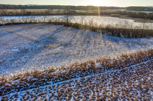 Drone Shot of a Grass Field Covered in Snow