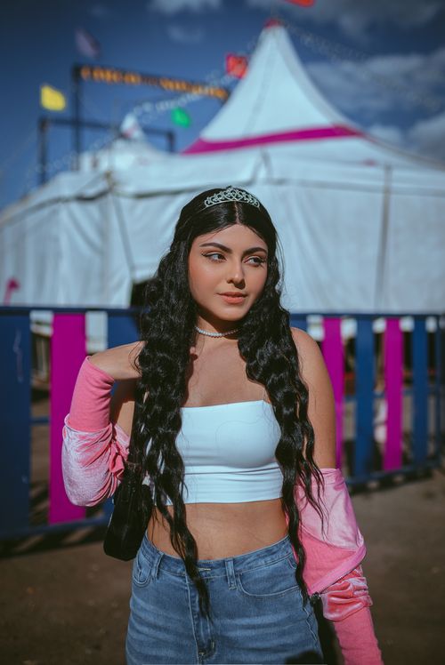 Free Young woman with tiara at a colorful festival outdoors. Stylish look capturing fashion in daylight. Stock Photo
