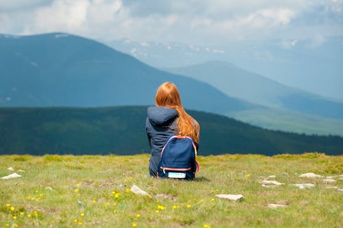 Free Person Wearing Gray Hooded Jacket Sitting on Grassy Field Stock Photo