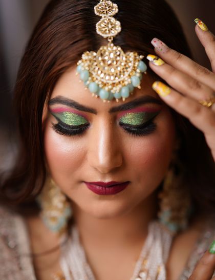 A bride wearing a mint kundan maang tikka